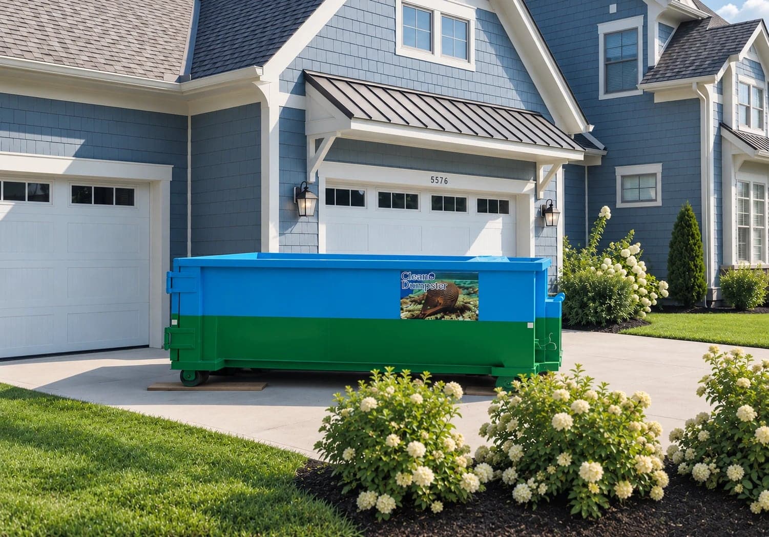 CleanE Dumpster roll-off container on wooden boards in the driveway of a two-story house